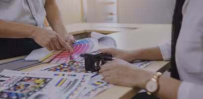 Bureau créatif avec croquis, stickers et palettes de couleurs, illustrant l’élaboration d’une charte graphique personnalisée