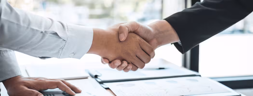 Poignée de main entre deux personnes en costume, symbolisant la collaboration professionnelle chez Keiyo