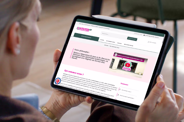 Une femme tient une tablette qui affiche le site d'Ananda pro