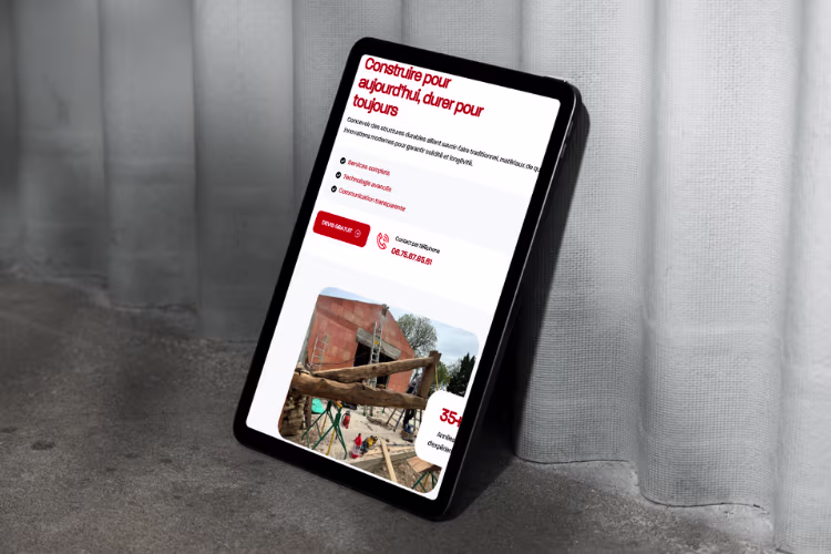 Présentation d'un service de Jp Charpente de leur site affiché sur une tablette posé contre un mur